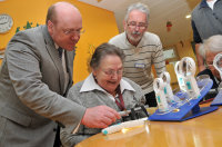 Prof. Dr. Burkhard Dick zeigt Bewohnerin Irmgard Dudek und Heimleiter Theo Elbers wie die neue Sehhilfe verwendet wird. Prof. Dr. Burkhard Dick zeigt Bewohnerin Irmgard Dudek und Heimleiter Theo Elbers wie die neue Sehhilfe verwendet wird.