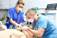 Die Mitarbeitenden trainieren, den Patienten-Dummy mit einem Schlauch über die Luftröhre zu beatmen. Bildnachweis: BG Universitätsklinikum Bergmannsheil Die Mitarbeitenden trainieren, den Patienten-Dummy mit einem Schlauch über die Luftröhre zu beatmen. Bildnachweis: BG Universitätsklinikum Bergmannsheil