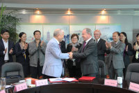 In aller Freundschaft: Vor einer deutsch-chinesischen Delegation haben Wilhelm Hecker (r.), Geschäftsführer des Herz- und Diabeteszentrums NRW, Bad Oeynhausen, und Cao Ming Fang (l.), Gründer der Unternehmensgruppe Jiangyin Mould Plastic, eine Vereinbarung zur Ausbildung von Fachkräften unterzeichnet (Foto HDZ NRW).