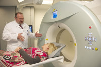 Dank neuer Software steigt die Qualität der CT-Aufnahmen. Prof. Burchert (l.) erläutert einer Patientin die neue Methode am PET-CT des Herz- und Diabeteszentrums NRW (Foto Armin Kühn).