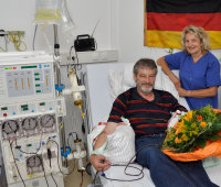 20 Jahre H.E.L.P.: Herbert Koer (l.), erster Patient der Lipidapherese-Therapie 1992, nimmt Blumen von Sabine Poggemöller, Fachpflegekraft im Herz- und Diabeteszentrum NRW, entgegen (Foto Armin Kühn).