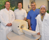 Foto (Armin Kühn): Abschiedsfoto am Modell des PET-CT, eines von wenigen Großgeräten für moderne Bildgebung in Deutschland, das im Herz- und Diabeteszentrum NRW zur Verfügung steht. Gastärztin Dr. Oktavia Lilyasari (re.) kehrt nach drei Monaten nach Indonesien zurück. Lebewohl sagen im Namen des gesamten Teams (v.l.) Oberarzt Dr. Thorsten Laser, Oberarzt Dr. Marcus Fischer und Oberarzt PD Dr. Nikolaus Haas.