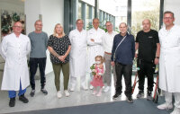 Strahlende Gesichter nach einer bisher nie dagewesenen, erfolgreichen Transplantationsserie im HDZ NRW: (V.l.) Jan Fleischhauer (Oberarzt der Transplantationsstation), Michael Grob, Andrea Nagel, Prof. Dr. Jan Gummert, Prof. Univ. (assoc.) Dr. Eugen Sandica, Julia (2 Jahre), Koordinator Artur Rajtor, Hans Nyenhuis, Manuel Pickard und Oberarzt Prof. Dr. René Schramm (Herzchirurg) (Foto: Kerstin Klughardt).