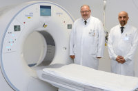 Schnellere, präzisere, sichere und schonende Diagnose: Prof. Dr. Wolfgang Burchert und Oberarzt Mohammad Rafi Mozafari mit dem modernsten Volumen-Computertomographen Deutschlands (Foto: Armin Kühn).
