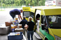Thomas Bartkowiak und Peter Schemionek helfen Fiona Zerres vom ASB beim Beladen des Transporters